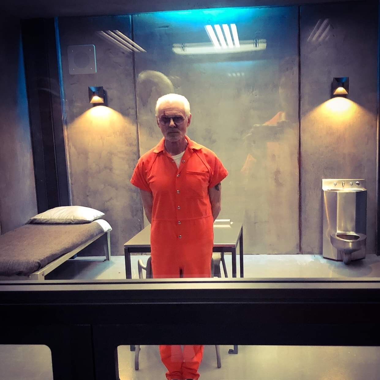 Angus MacGyver Trucs et Astuces - 3x18 Les virtuoses - Michael Des Barres en cage, photographié par David Dastmalchian que l'on aperçoit dans le reflet de la vitre, et publié sur les réseaux sociaux, de retour pour le plus grand bonheur des fans